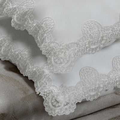 Cattedrale Lace ivory cotton pillowcases with scalloped lace trim, folded on linen fabric.