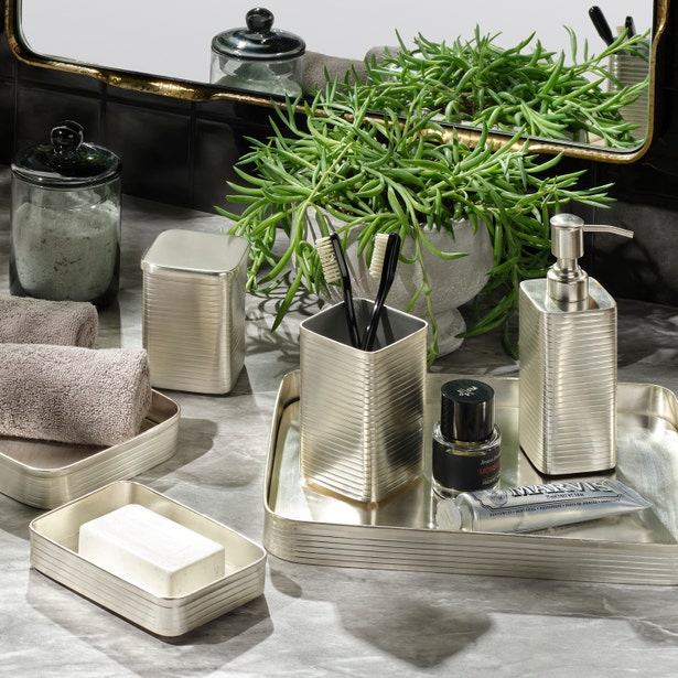 Adelaide bath accessories set in champagne, ribbed metal finish styled on marble counter.