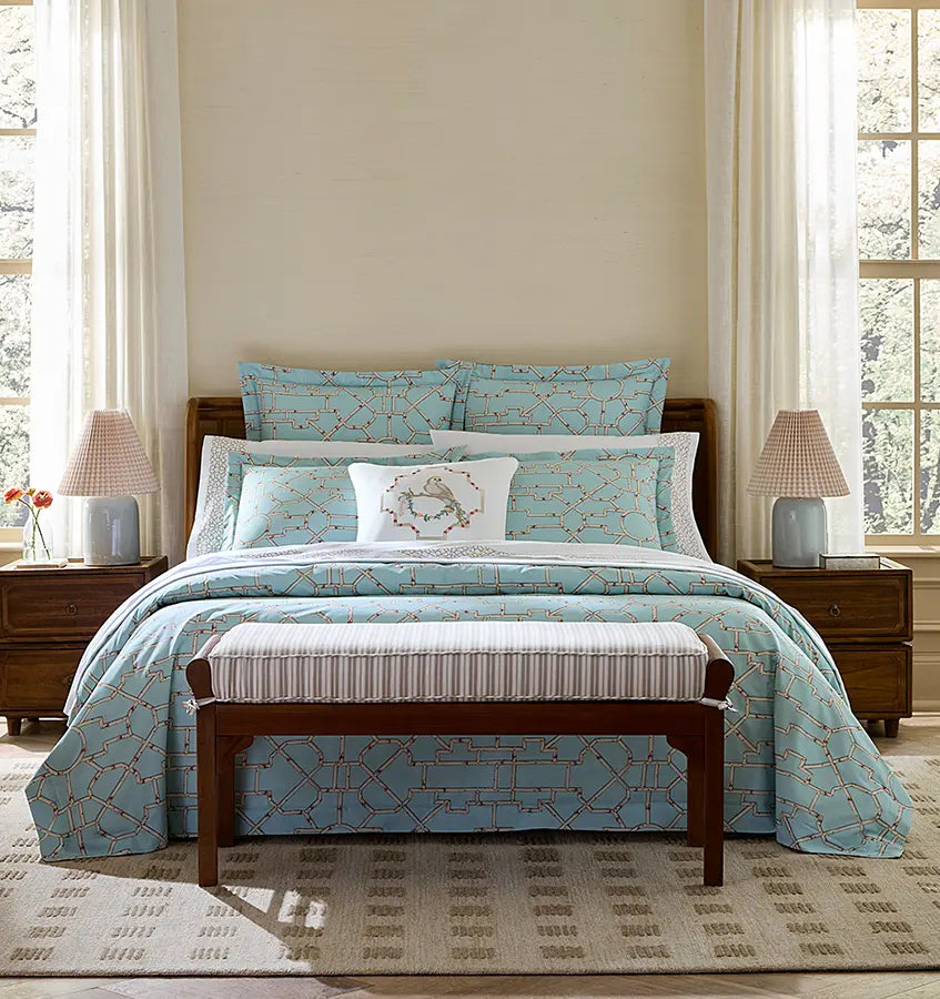 Baldwin Bamboo aqua bedding set with coral geometric pattern on made bed.