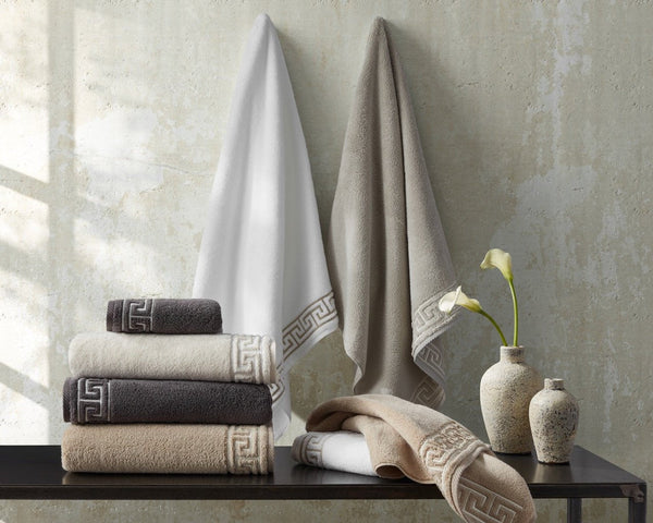 Matouk Adelphi towels stacked on table.