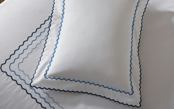 Axel Zig-Zag white cotton bedding with navy and blue zigzag embroidered border.