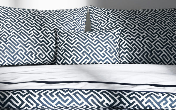 Gabriel navy and white geometric maze print bedding set with pillows and white sheets.