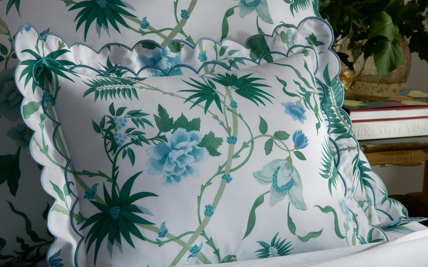 Palmyra scalloped pillow sham in white with teal and blue botanical print.