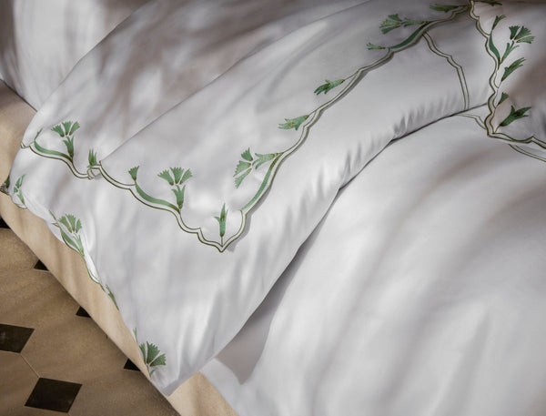 Marcella Floral Sateen white bedding with green embroidered floral vine detail.