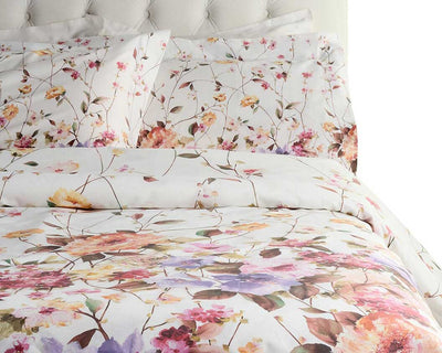 A bed with white sheets, pillowcases, and a comforter featuring a colorful floral print in tones of pink, orange, and purple.