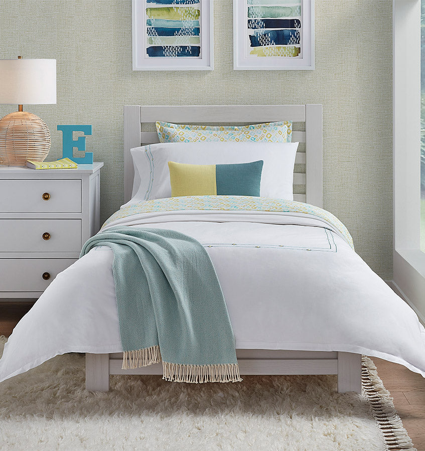 Diamantini white bedding set with seafoam throw and yellow and teal accent pillows.