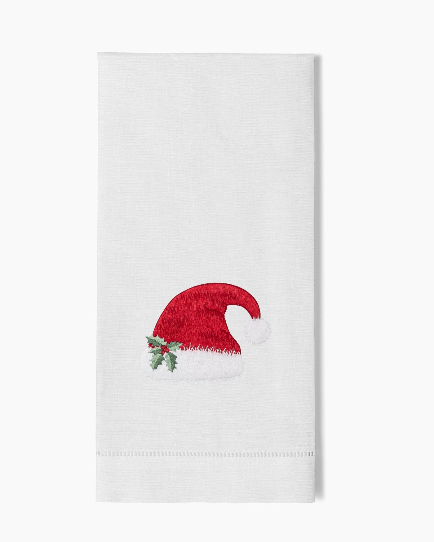 White linen hand towel with embroidered red Santa hat and holly detail.
