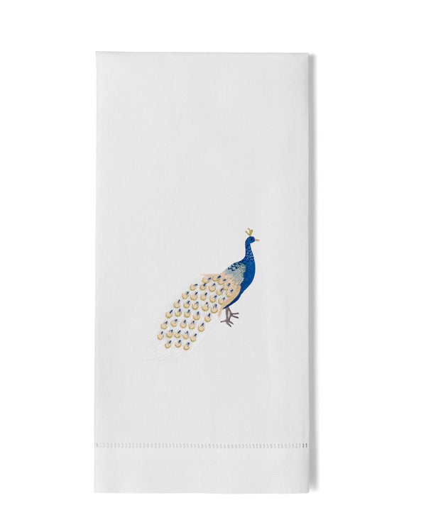 White linen hand towel with embroidered peacock in cobalt blue and gold, hemstitch border.