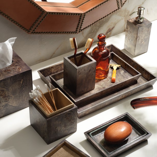 Bern Bath collection styled on marble vanity, dark wood trays and canisters with accessories.