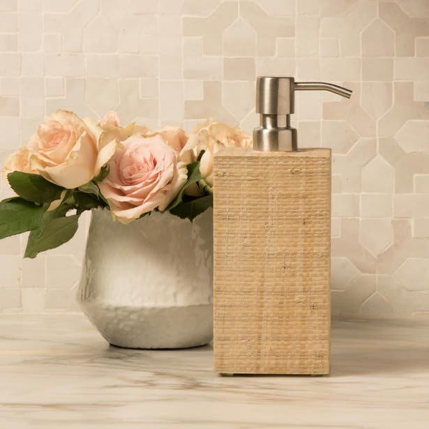 Ghent natural raffia soap dispenser with brushed nickel pump, styled on marble surface.