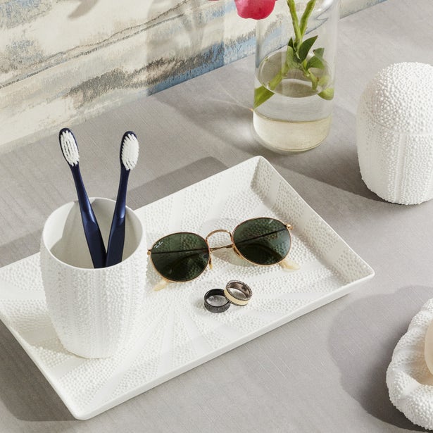 Hilo bath collection in white, styled tray with toothbrush holder, sunglasses, and rings.