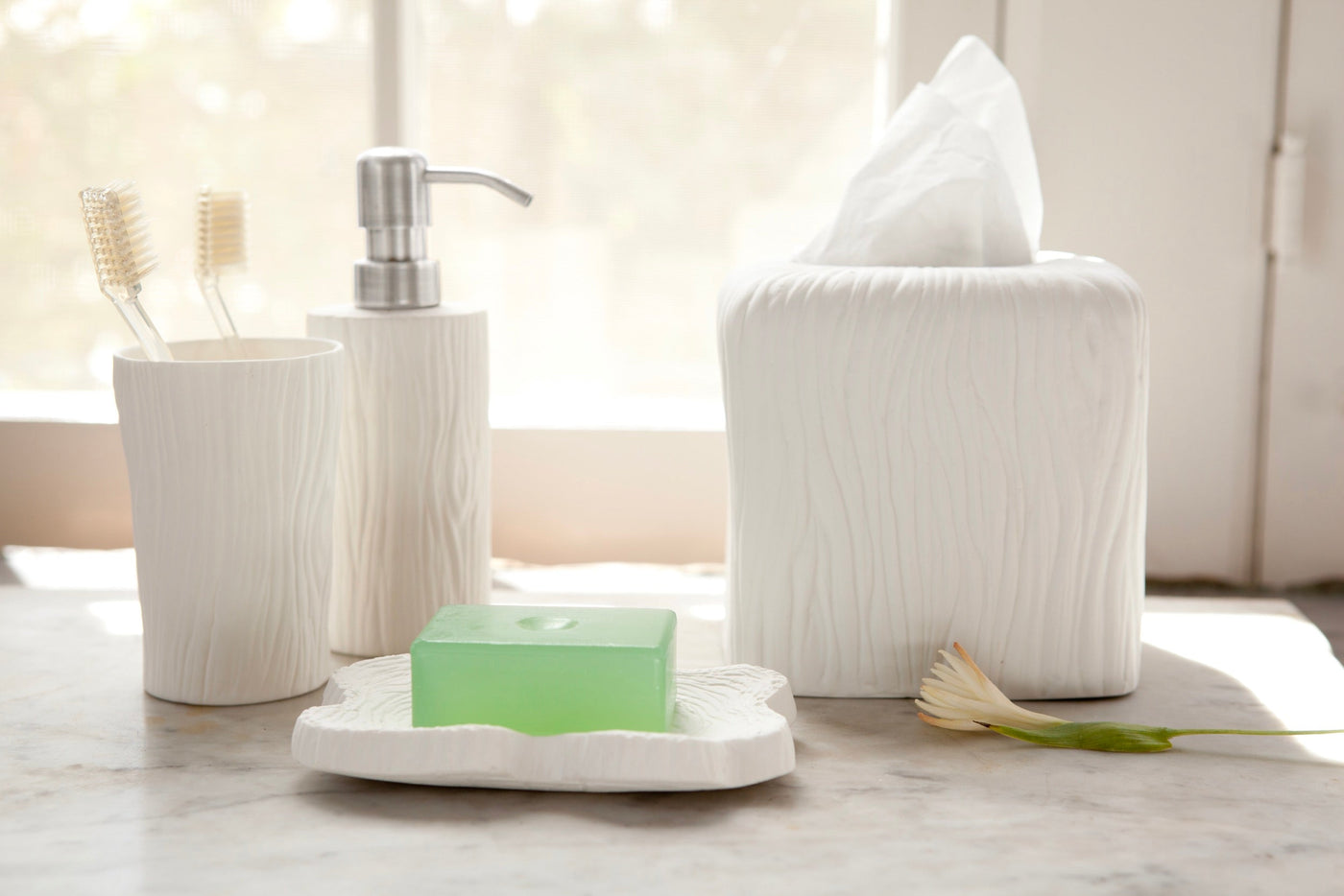Burma bath accessories in white with wood-grain texture, styled on marble with natural light.