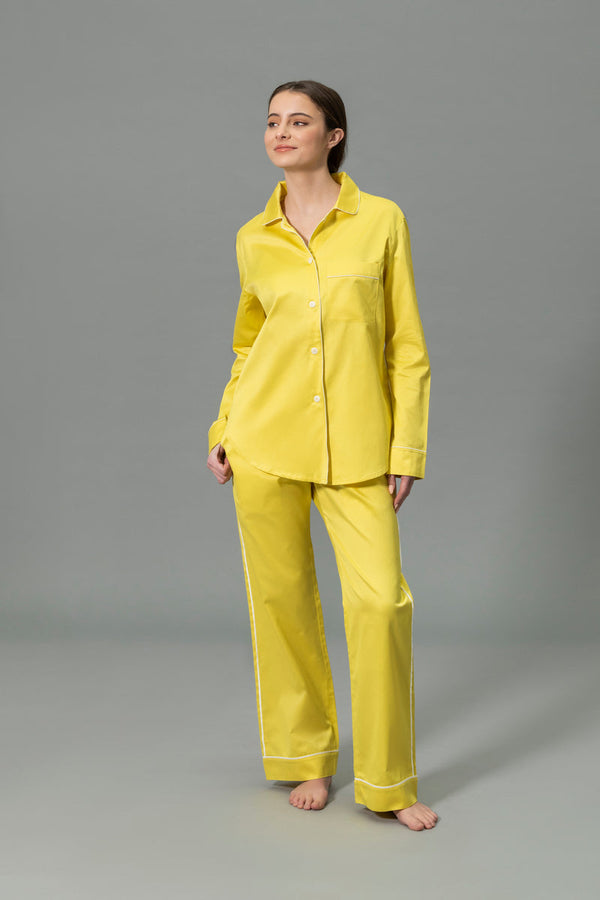 A variety of folded and laid-out pajamas in different colors, including blue, yellow, pink, brown, lavender, black, and light blue, displayed on a gray surface.