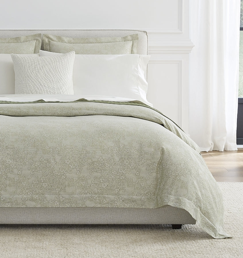 Sferra Rialto sage green damask duvet cover styled on a bed with white pillows.