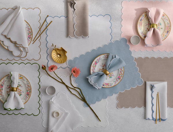 Dakota scallop-edge placemats and napkins in ivory, blush, and sky blue with floral plates.