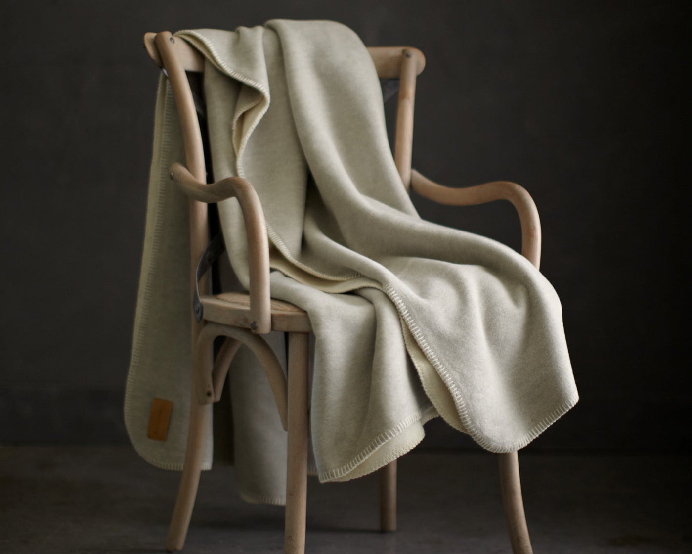Reversible whipstitch cotton blend blanket Alta by Peacock Alley draped over chair