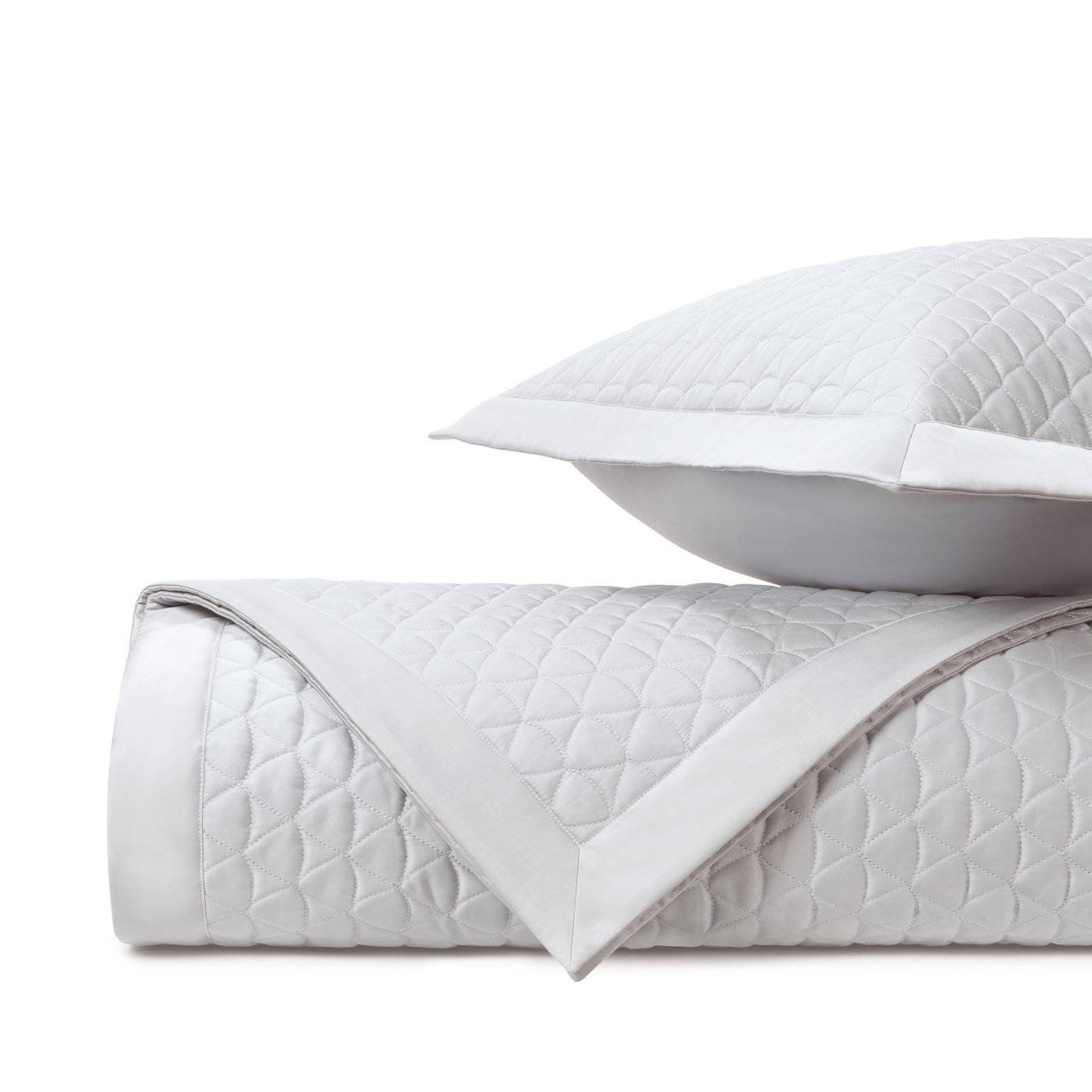 Anastasia white quilted coverlet rolled with diamond pattern and matching sham.