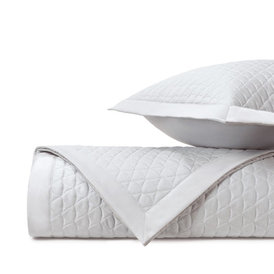 Anastasia white quilted coverlet rolled with diamond pattern and matching sham.