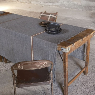 Arlo Stripe slate linen tablecloth with contrast border on rustic wooden table.