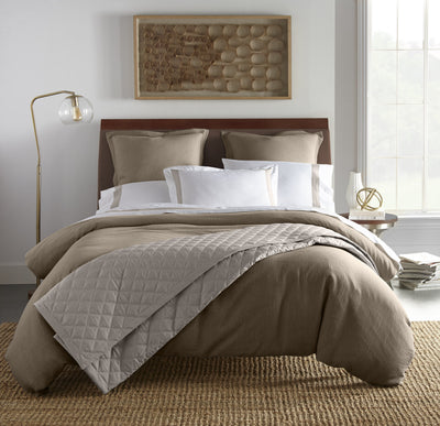 Atacama taupe linen duvet cover with quilted stone coverlet on made bed.