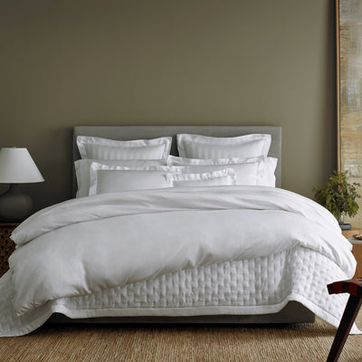 Sferra Athens white Egyptian cotton bedding with satin border on styled bed.