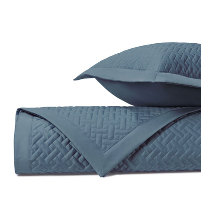 Basketweave quilted coverlet and sham in slate blue with geometric stitch pattern.