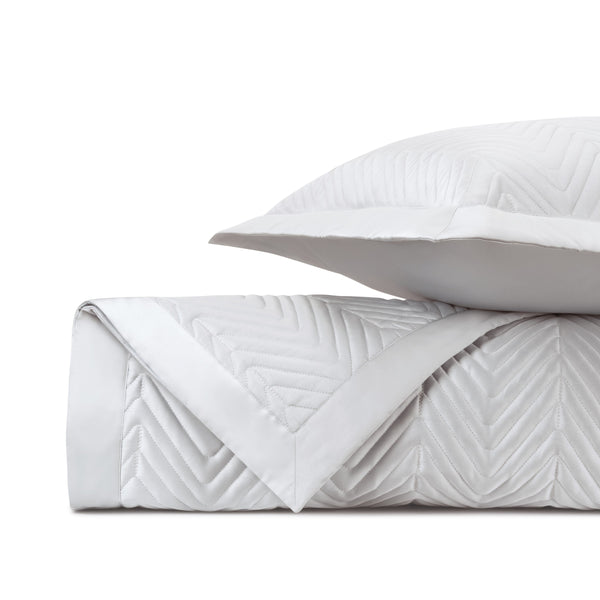 Charleston quilted white coverlet and pillow sham with chevron stitching, neatly folded.