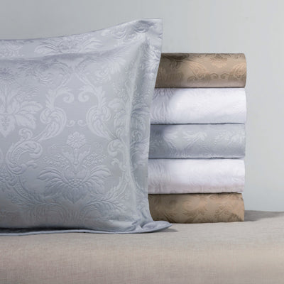 Sferra Chelsea jacquard damask pillow sham and folded sheets in silver and taupe.