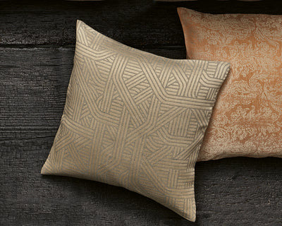 Two decorative pillows on a dark wooden surface; one pillow has a beige geometric pattern and the other has a textured, light brown floral design.