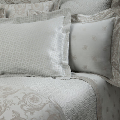 Sferra Firenze ivory jacquard bedding with medallion pattern, styled on a made bed.
