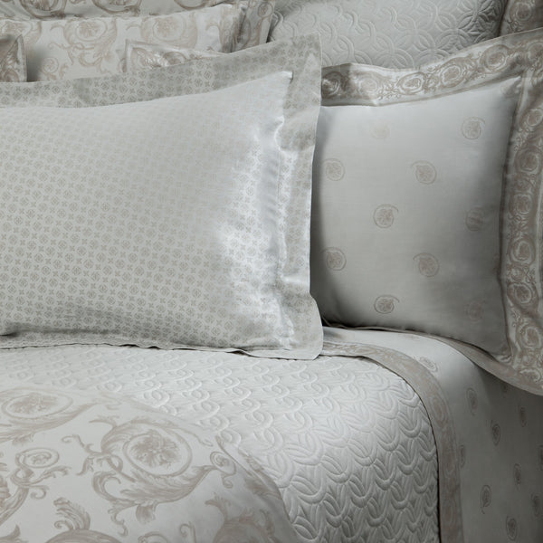Home Treasures Firenze ivory jacquard bedding with medallion pattern, styled on a made bed.