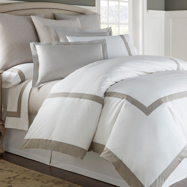 Home Treasures Gaia white and taupe cotton bedding set styled on a made bed.
