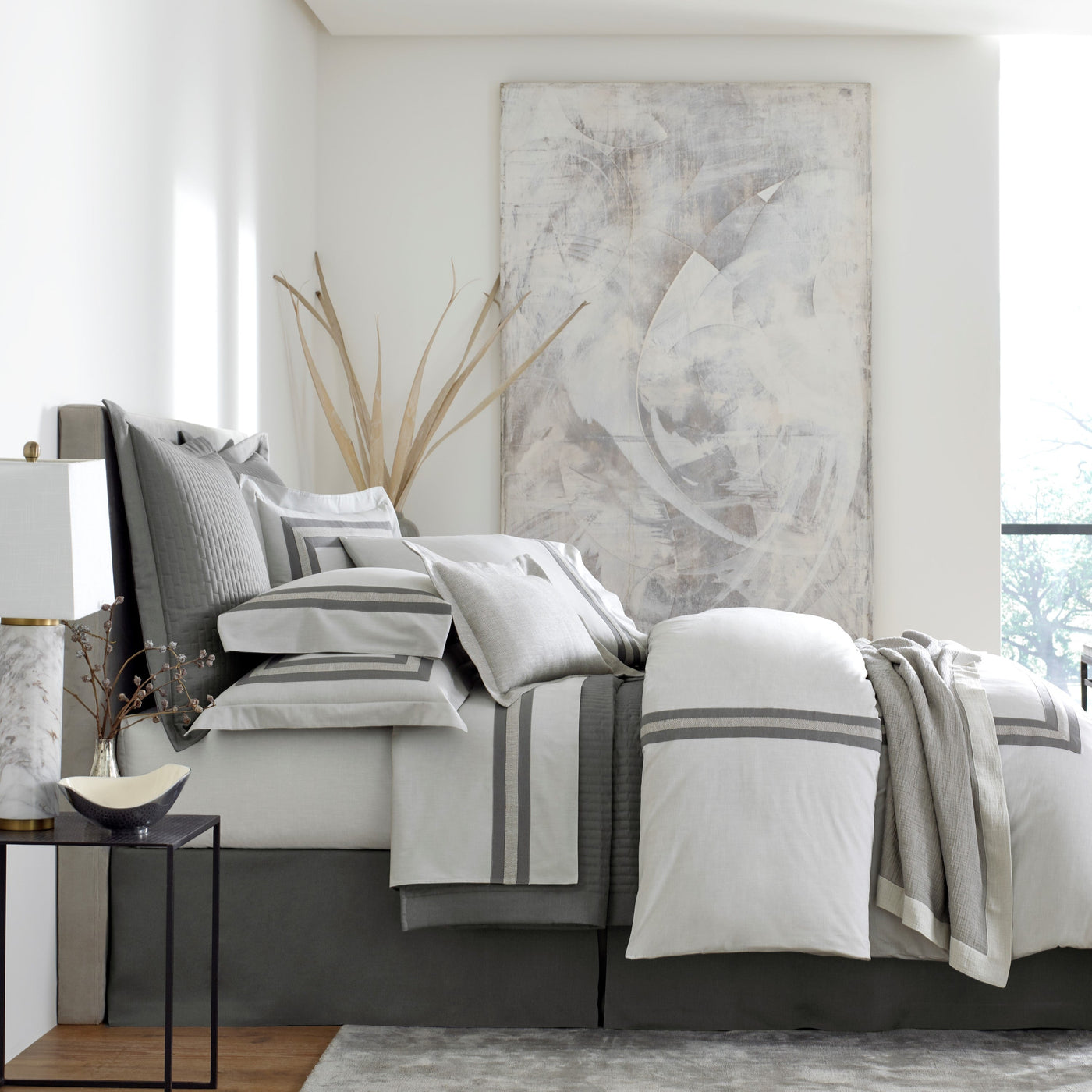 Sferra Harper white and graphite cotton bedding collection styled on a bed.