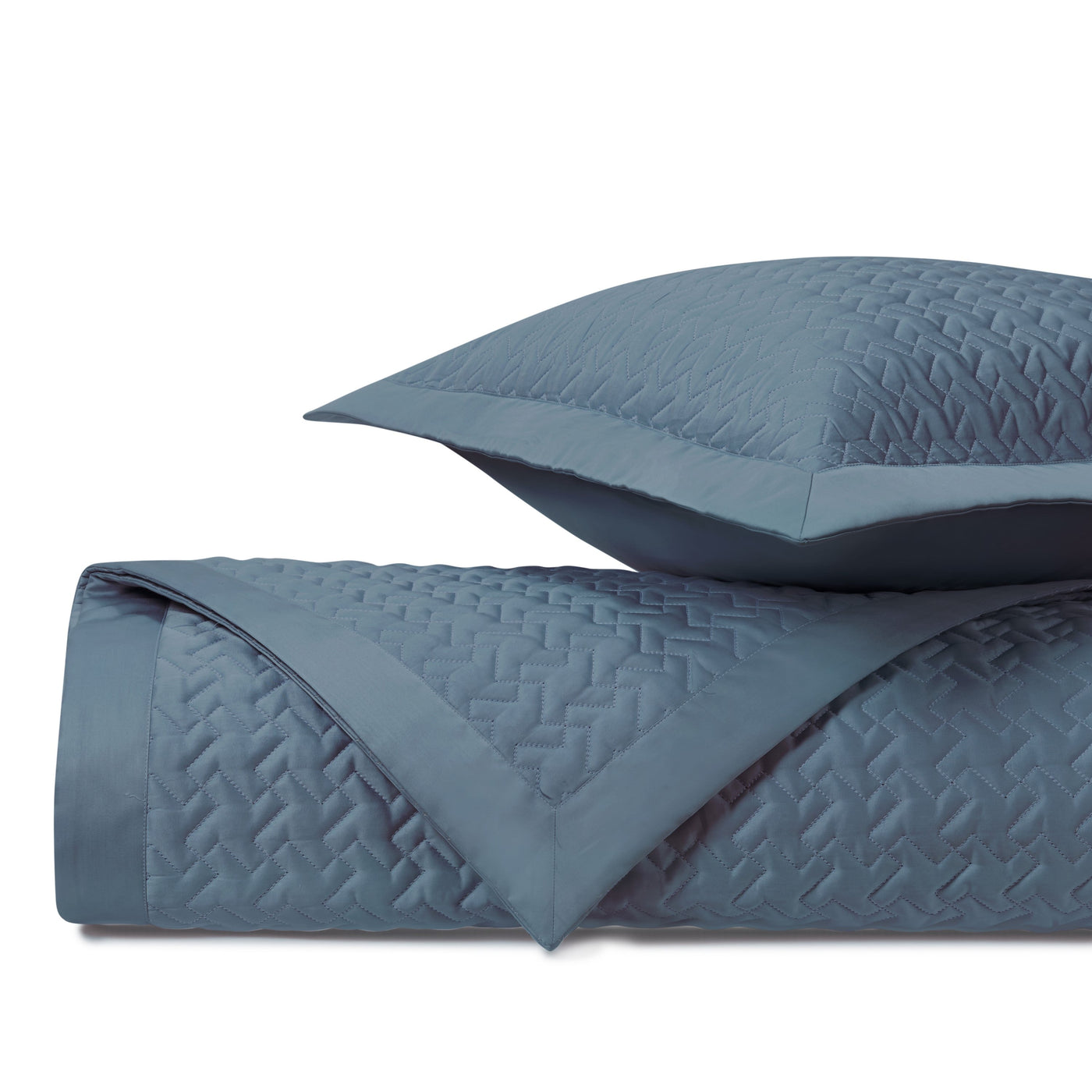 Houndstooth slate blue quilted coverlet and sham with geometric stitched pattern.