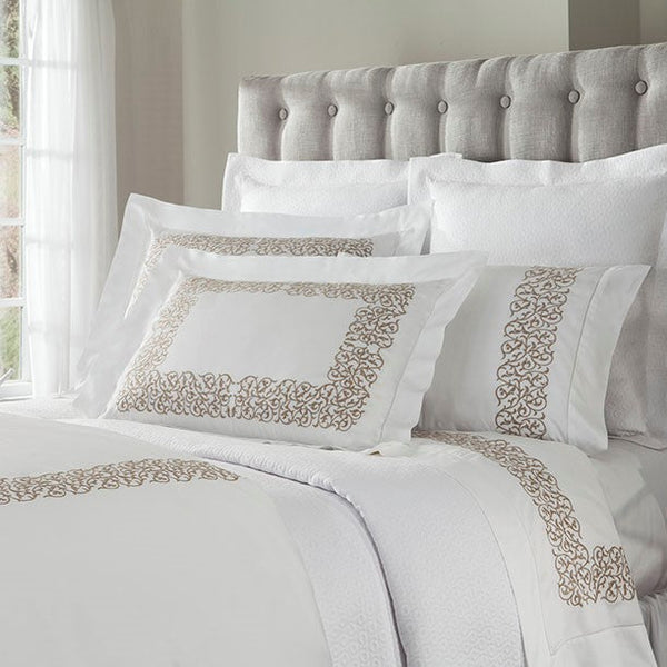 Home Treasures Jasmine white bedding with champagne embroidered scroll border on bed.