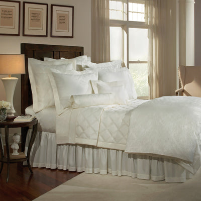 Sferra Luciana ivory matelassé bedding collection styled on bed with quilted coverlet and pillows.