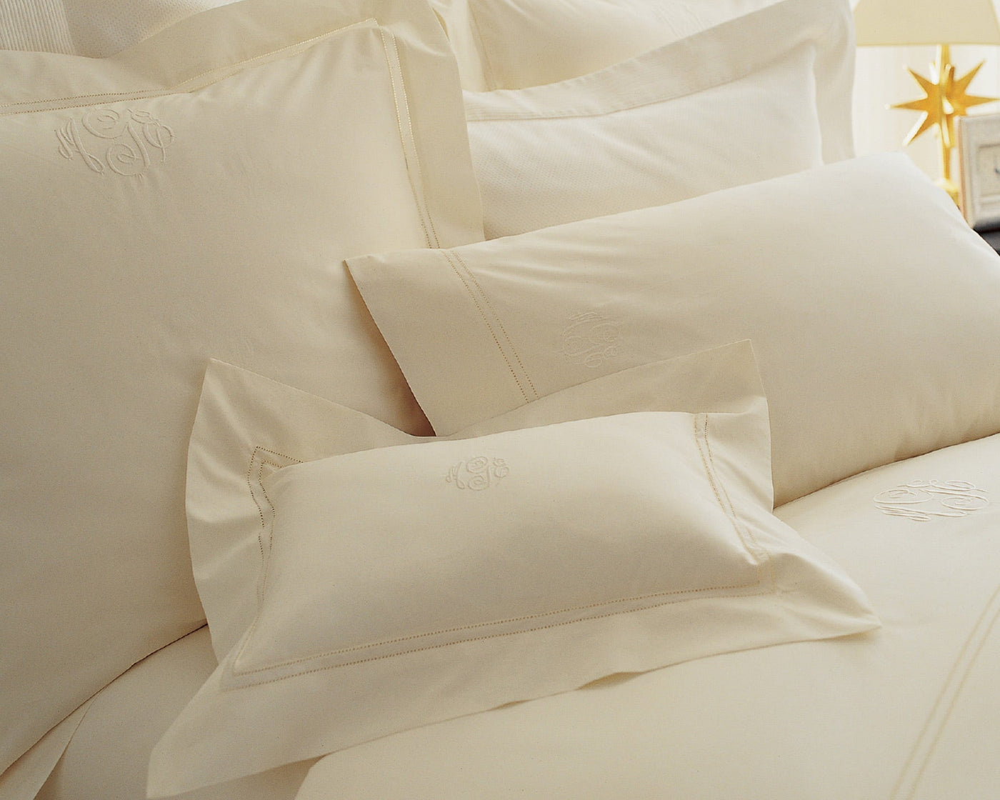 Luxury bedding collection Lyric cotton percale shams and cases in ivory on plush bed