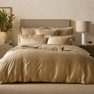 Sferra Mulberry champagne silk duvet cover and shams on styled bed.