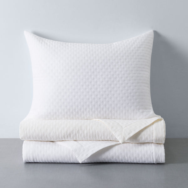 Nimbus ivory quilted bedding set with textured diamond pattern, folded duvet and euro sham.