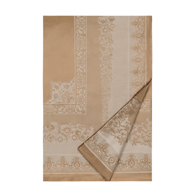 Sferra Persia flat sheet in champagne with woven floral medallion border, corner folded back.