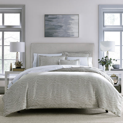Sferra Raja silver jacquard duvet cover on styled bed with coordinating shams.
