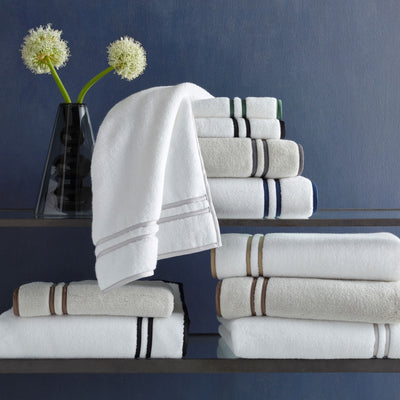 Matouk Ribbons white cotton bath towels with contrast stripe borders in multiple colorways.