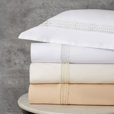 Sferra Wreath folded sheet sets in white, ivory, and champagne with embroidered trim.