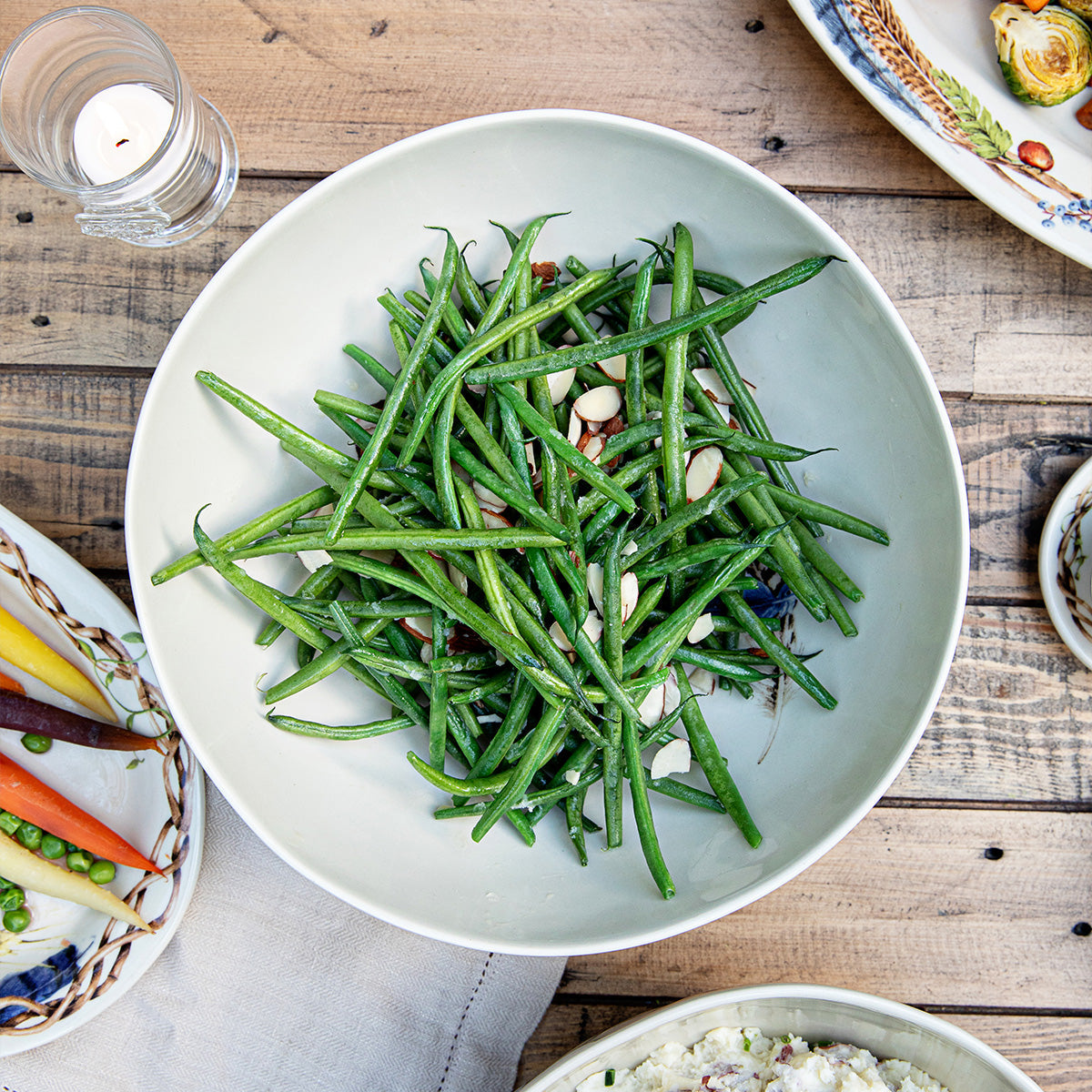 Forest Walk 10 inch serving bowl filled with green beans, viewed from above on a wooden table