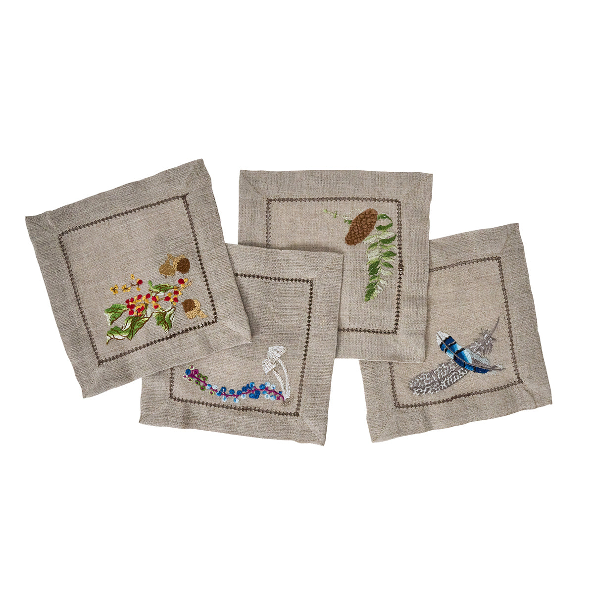 Juliska Forest Walk linen cocktail napkins fanned out, showing embroidered woodland motifs