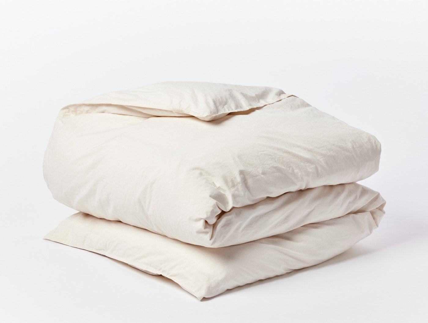 Coyuchi Crinkled Percale duvet cover folded, ivory, soft crinkled texture visible.