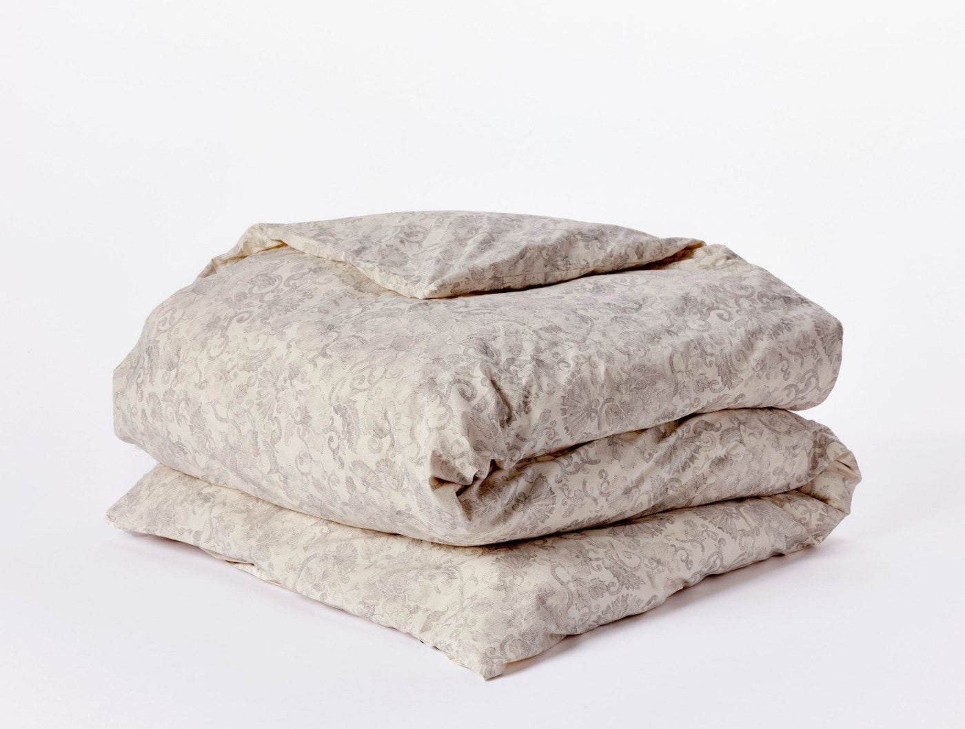 Folded ivory duvet cover with subtle tone-on-tone floral damask print, stacked view.