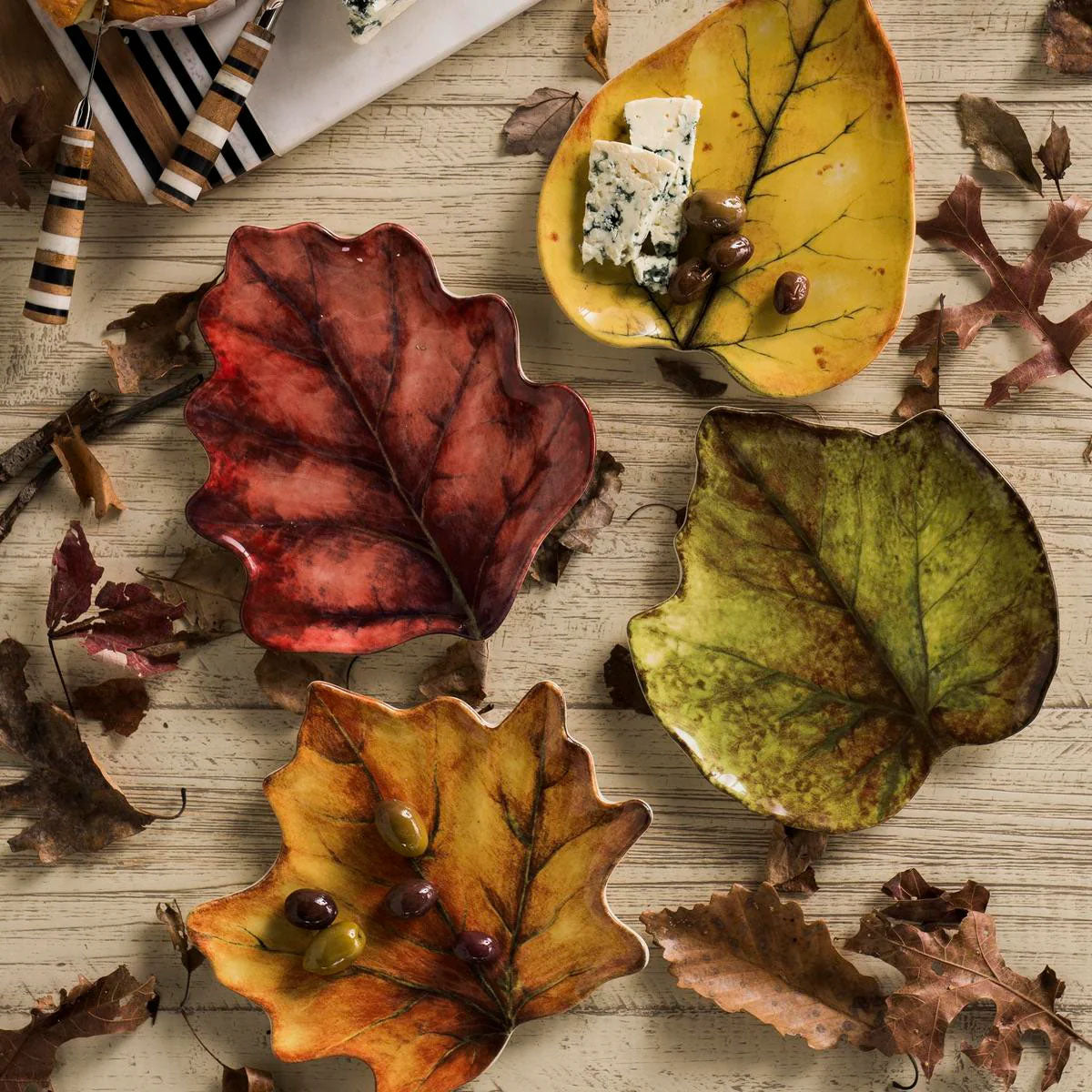 Forest Walk leaf cocktail plates with cheese and grapes on a wood table scattered with dried leaves