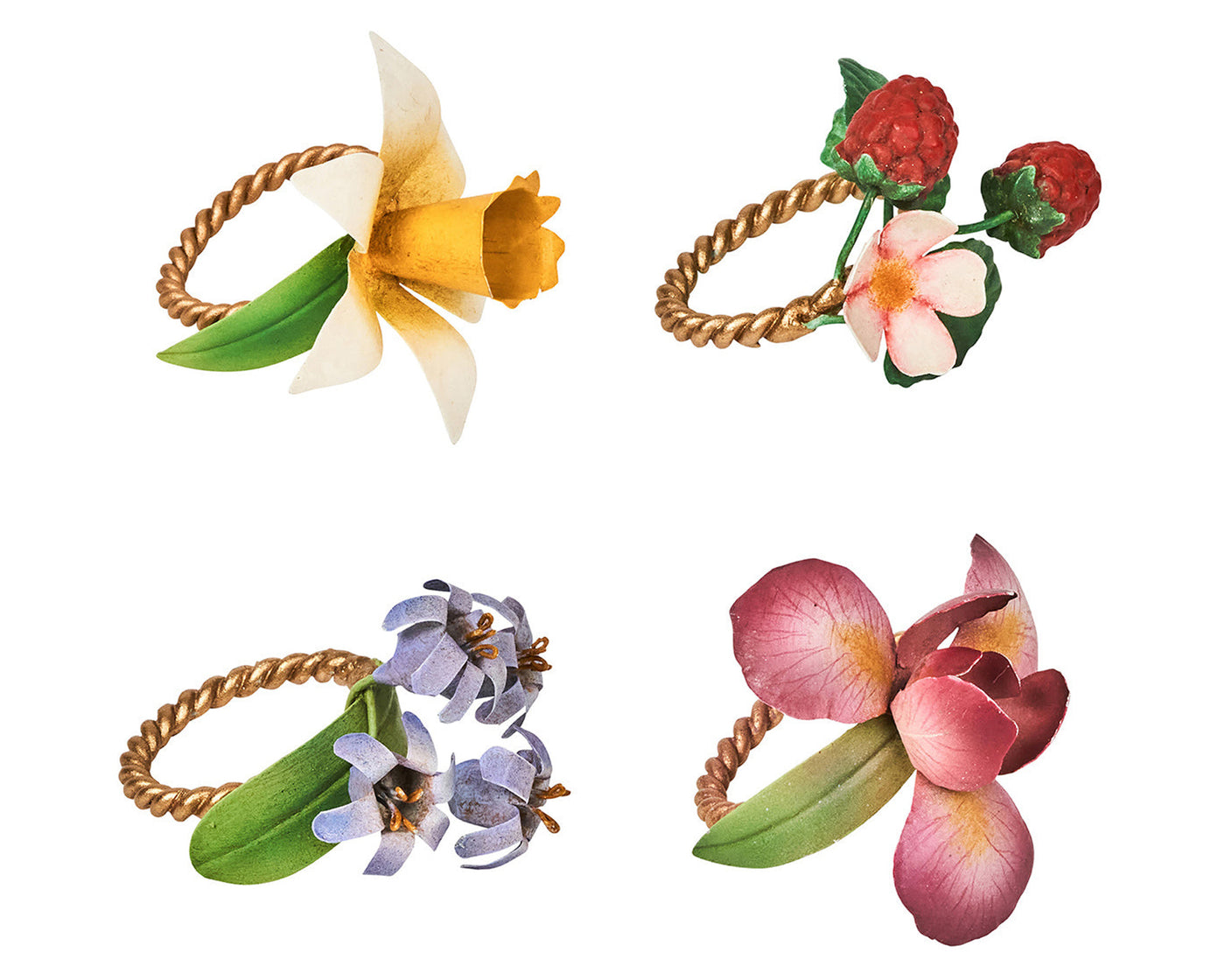 Close-up of four Juliska Meadow Walk napkin rings with floral and berry botanical motifs on twisted gold rings.