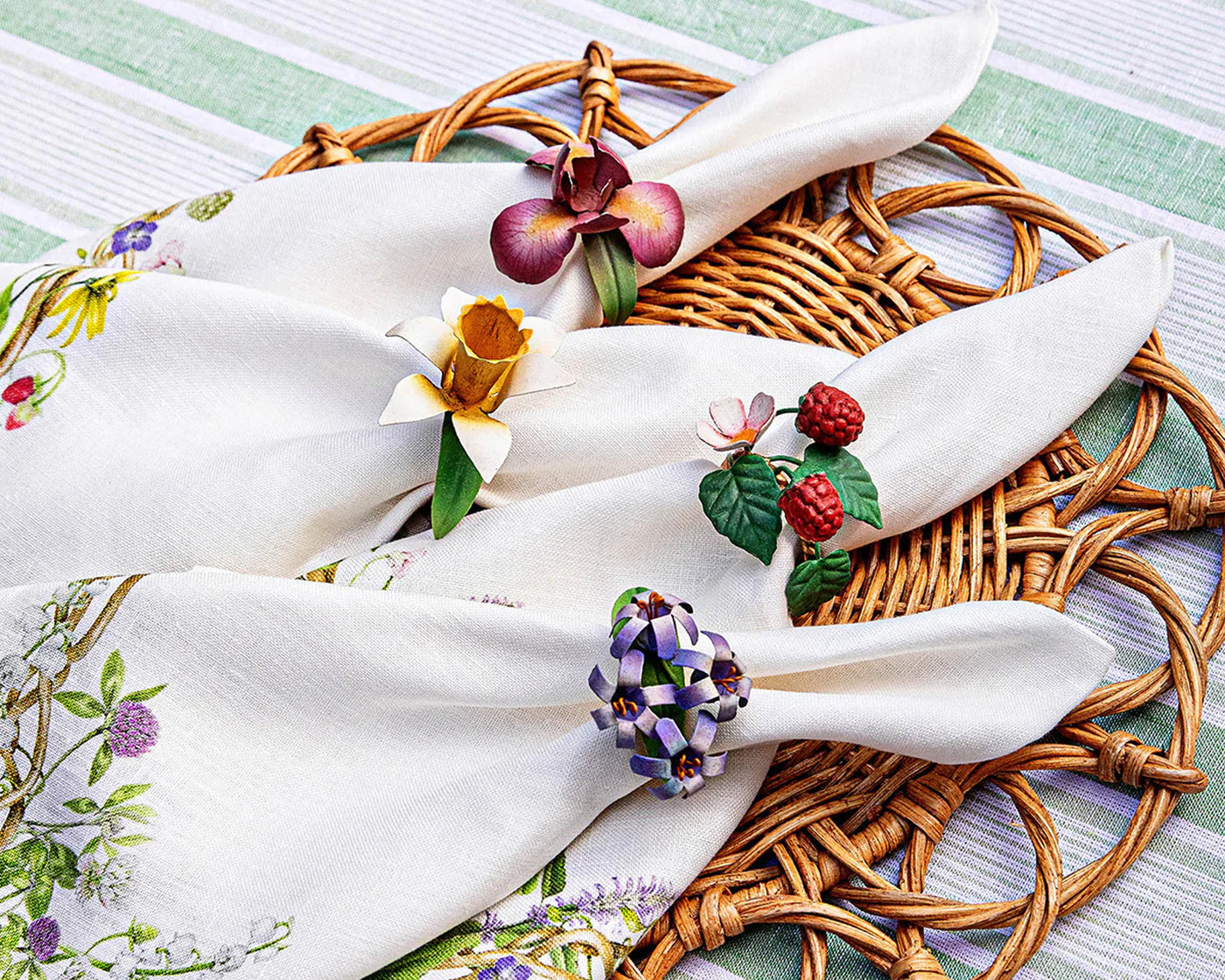 Juliska Meadow Walk napkin rings with floral and berry motifs on white linen napkins.